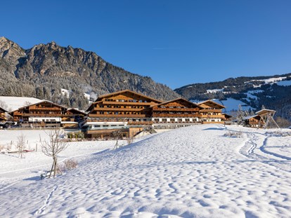Wellnessurlaub - Parkplatz: kostenlos beim Hotel - Winterliche Südansicht des Hotels mit Bergen im Hintergrund - Alpbacherhof****s - Mountain & Spa Resort