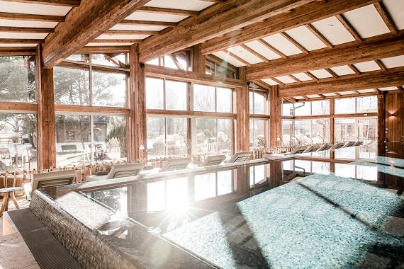 Entspannen Sie im lichtdurchfluteten Infinity Pool mit Blick auf den Garten im DAS ACHENTAL