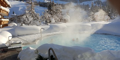 Wellnessurlaub - Pools: Schwimmteich - Großarl - Whirlpool und Schwimmbad im Schnee - Gartenhotel Theresia****S - das "grüne", authentische Hotel.