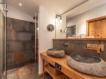 Wellnessurlaub - Kräutermassage - Kössen - Badezimmer in einem Chalet - Gut Steinbach Hotel und Chalets