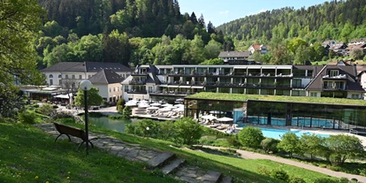 Wellnessurlaub - Ladestation Elektroauto - Ottenhöfen im Schwarzwald - Parkanlage mit Sicht auf das Hotel mit dem Thermalbad - Hotel Therme Bad Teinach