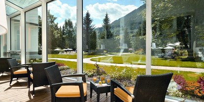 Wellnessurlaub - Wirbelsäulenmassage - Bad Hofgastein - Wandelgang aus Glas mit Panorameblick - CESTA GRAND Aktivhotel & Spa