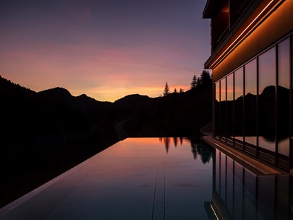 Wellnessurlaub - Pools: Außenpool beheizt - Lech - Infinitypool im Sonnenuntergang - Alpenstern Panoramahotel