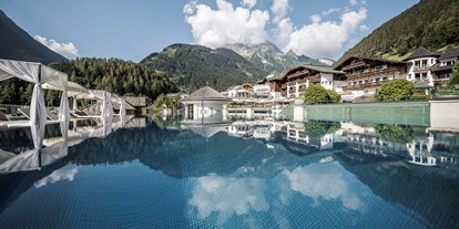 Wellnessurlaub - Finnische Sauna - Ratschings - Pool Ansicht Richtung Hotel & Grünberg - STOCK resort *****s