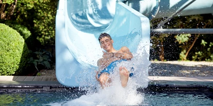 Wellnessurlaub - Pools: Sportbecken - Völs am Schlern - Kinderpool mit 35 Meter langer Wasserrutsche im Garten - Feldhof DolceVita Resort