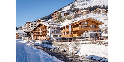 Wellnessurlaub - Parkplatz: gebührenpflichtig beim Hotel - Samnaun Dorf - Aussenansicht Hotel Auenhof in Lech im Winter - Hotel Auenhof