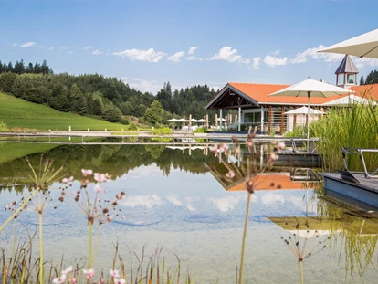 Wellnessurlaub - Aromamassage - Lauben (Landkreis Oberallgäu) - Das Haus am See mit Natursee im Sommer. - Haubers Naturresort
