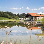 Wellnesshotel - Das Haus am See mit Natursee im Sommer. - Haubers Naturresort
