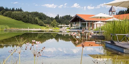 Wellnessurlaub - Pools: Außenpool beheizt - Oberstdorf - Das Haus am See mit Natursee im Sommer. - Haubers Naturresort