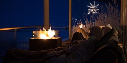 Wellnessurlaub - Entgiftungsmassage - Allgäu - Das Feuer auf der Terrasse beim Haus am See sorgt für Wärme und Erholung. - Haubers Naturresort