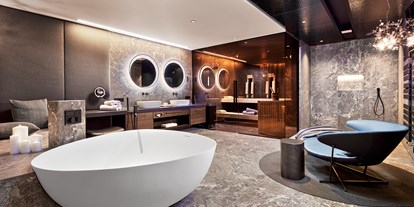 Wellnessurlaub - Hot Stone - Badezimmer der Luxury-Suite mit eigener Sauna, freistehende DUO-Badewanne mit Regensystem, 
Wärmebank und Relax-Bereich - 5-Sterne Wellness- & Sporthotel Jagdhof