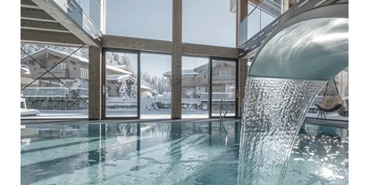 Wellnessurlaub - Hotel-Schwerpunkt: Wellness & Beauty - Oberösterreich - INNs HOLZ Ausblick vom Indoorpool auf das Chaletdorf im Winter - INNs HOLZ Chaletdorf