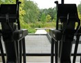Wellnesshotel: Blick aus der Fitnesshalle in den Garten mit Schwimmteich - Essensio Hotel 