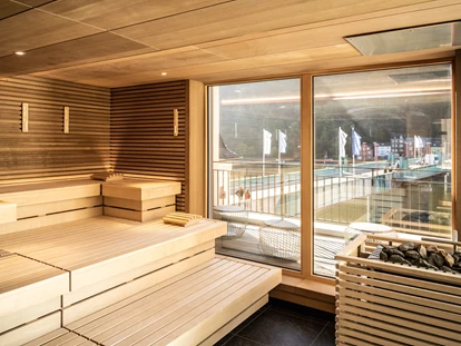 Wellnessurlaub - Kelberg - Finnische Sauna
Die Finnische Sauna ist mit 25 m² die größte Sauna. Temperaturen mit bis zu 90°C, ein automatisches Aufgusssystem und das Panoramafenster mit direktem Moselblick sorgen für ein perfektes Saunaerlebnis. Espensitzbänke und die Wand- und Deckentäfelung aus Eiche entführt Ihre Sinne in die Natur. Regelmäßig werden hier eigene Saunaaufgüsse angeboten. Die Aufgusszeiten erfahren Sie im Tagesprogramm – ein Muss für jeden Saunafan. - Moselschlösschen Spa & Resort