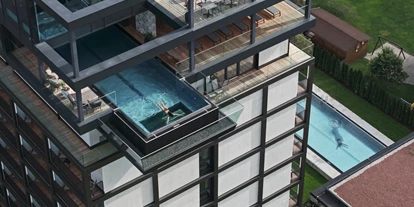 Wellnessurlaub - Finnische Sauna - Perg - Außenansicht mit SKY-Pool in 36 m Höhe und Außenpool (indoor und outdoor) im Wellnessgarten. - Hotel FREIGOLD