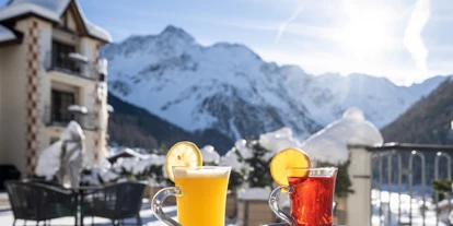 Wellnessurlaub - Pilates - Fruchtigen Punsch beim Relaxen in der Wintersonne auf der Terrasse genießen - 4-Sterne-Superior Alpin Spa Hotel die Post in Südtirol