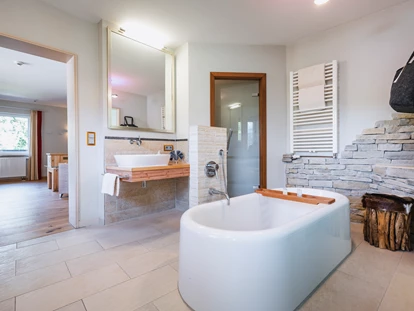 Wellnessurlaub - Fontanella - Wellnesssuite Badezimmer mit Blick in den Wohnbereich - Wellnesshotel Walserhof