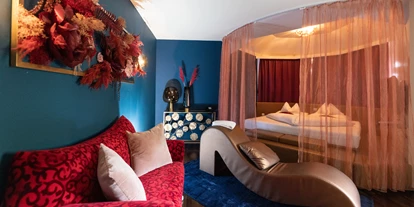 Wellnessurlaub - Restaurant - Stegersbach - Grand Penthouse Paradise Suite 
Das ultimative Luxuserlebnis erstreckt sich über 90 m², auf zwei Etagen, verbunden mit einer Marmor-Wendeltreppe. Modernes, italienisches Design und das Ambiente sorgen für romantische Momente. Im Obergeschoß sorgt ein großes Kuschelbett für prickelnde Stunden zu zweit. Das „Open-Space“ Badezimmer bietet einen Air-Pool, eine große Dusche, einen Fön und ein separates WC. Die zweistöckige Suite bietet eine finnische Sauna von „Klafs“ mit Blick in den Wohnbereich. Mehrere LED TVs mit Blu-Ray Player sorgen zusätzlich für Unterhaltung. Vom großen Balkon der Suite haben Sie perfekten Blick auf den Liebesgarten, sowie auf die Therme Loipersdorf. Für zusätzliche Romantik sorgen ein elektrischer Zimmerkamin, sowie ein „Bretz“ Kuschelsofa. Die Klimaanlage sorgt für die nötige Abkühlung nach heißen Stunden. Weiters bietet die Suite eine Zimmerbar mit Kaffeemaschine und einen Zimmersaf - Maiers Kuschelhotel Loipersdorf Deluxe