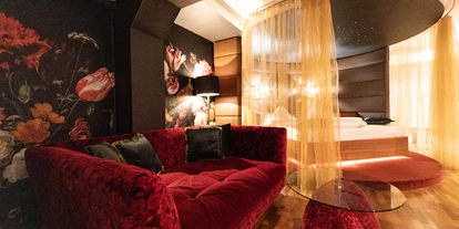 Wellnessurlaub - Restaurant - Stegersbach - Garden Suite 
In modernem italienischen Design präsentiert sich die Garden Suite auf 50m² im Erdgeschoss des Kuschelhotels. Als Besonderheit genießen Sie hier einen Privatgarten, gut geschützt im überdachtem Sitz- und Loungebereich den Ausblick genießen. Ein Kuschelbett mit zuziehbarem Vorhang und Sternenhimmel sorgt für romantische Stunden. Das „Open-Space“-Badezimmer bietet einen Air-Pool, eine große Dusche, einen Fön und ein separates WC. Indoor bietet die Suite ein „Bretz“ Sitzsofa und einen Essbereich für ein romantisches Dinner zu zweit. Für die heißen Stunden ist die Suite mit einer Klimaanlage versehen. Das Angebot wird durch eine Minibar mit Kaffeemaschine, einem Zimmertresor, einem Telefon und einem LED TV mit Blu-Ray Player abgerundet. - Maiers Kuschelhotel Loipersdorf Deluxe