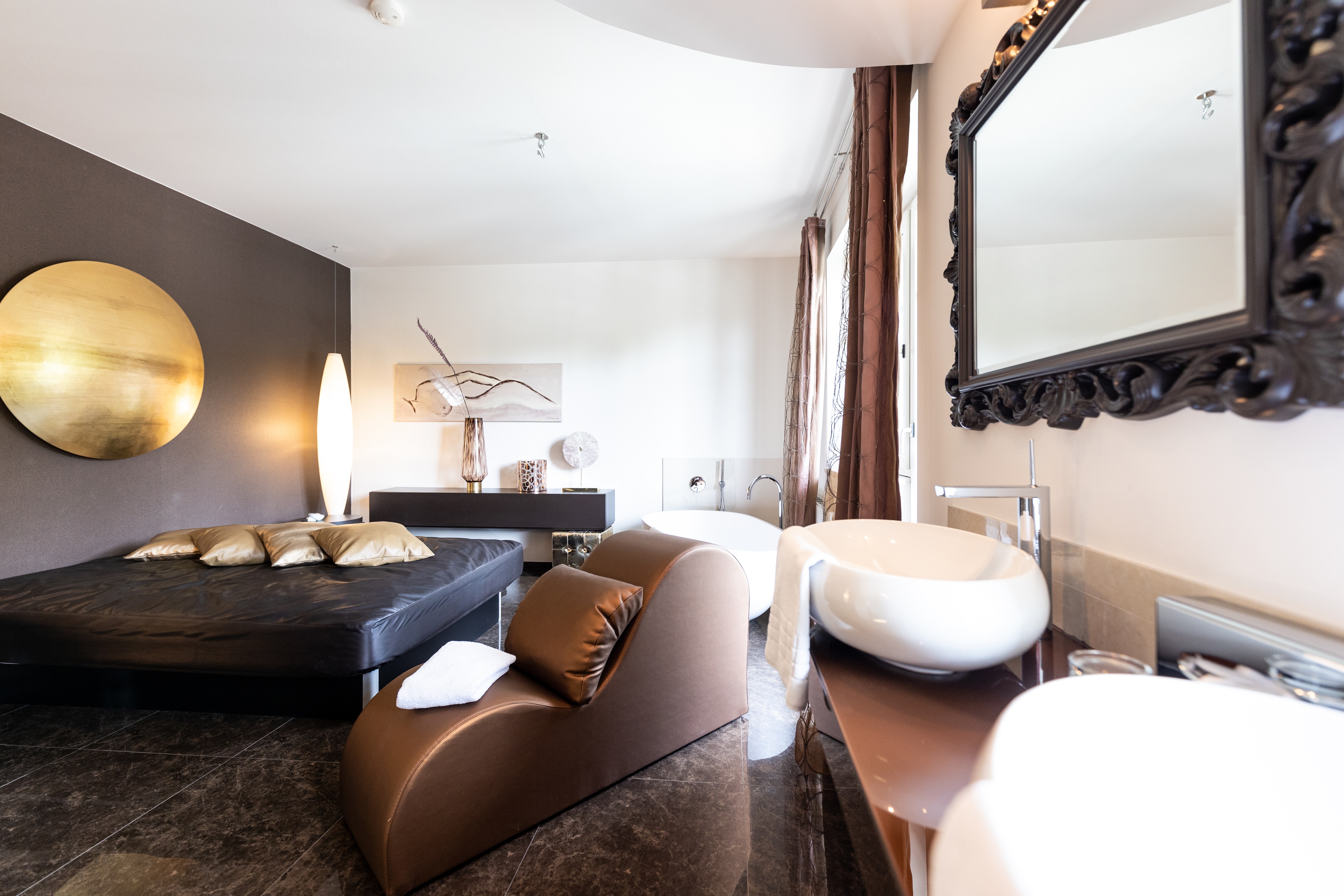 Wellnesshotel: Grand Fantasy Suite Die Grand Fantasy Suite sorgt mit ihren 80m² für prickelnde Momente zu zweit. Die Basis hierfür bietet ein extragroßes „Seally“ Deluxe Bett. Das „Open-Space“ Badezimmer besitzt eine große Dusche, einen Fön und ein separates WC mit Bidet. Die freistehende Badewanne dient als echte - Maiers Kuschelhotel Loipersdorf Deluxe  - Zimmer | Suiten