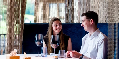 Wellnessurlaub - Babysitterservice - Paar genießt einen Abend im Sterne-Restaurant "dahoam" - Good Life Resort Riederalm