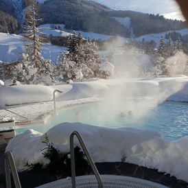 Wellnesshotel: Whirlpool und Schwimmbad im Schnee - Gartenhotel Theresia****S - das "grüne", authentische Hotel.