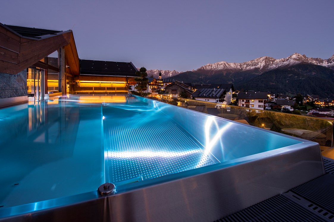 Wellnesshotel: Infinity Pool bei Night  - Hotel Tirol
