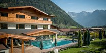 Wellnessurlaub - PLZ 6370 (Österreich) - Gartenanlage mit Aussenpool und Schwimmteich  - Wellness & Familienhotel Kitzspitz