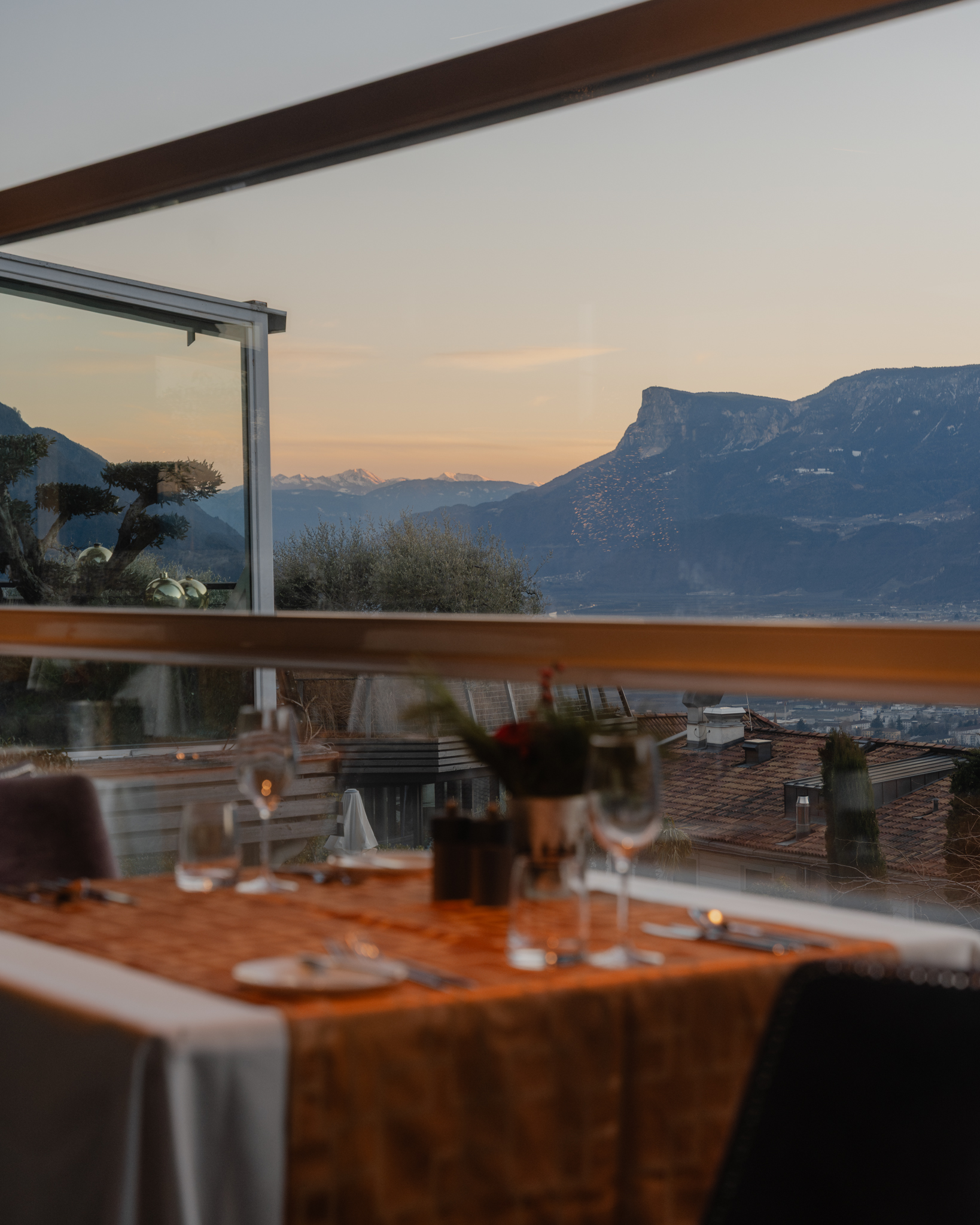 Wellnesshotel: Ein stilvoll gedeckter Tisch mit Panoramablick: Im Spa & Relax Hotel Erika genießen Sie Ihr Dinner in ruhiger Atmosphäre, während die Abendsonne die Berge in warme Farben taucht. Durch die großen Glasfronten öffnet sich der Blick weit über das Tal – perfekt für genussvolle Stunden, begleitet von feiner Küche und einem Hauch von Romantik. - Spa & Relax Hotel Erika - Hotel | Umgebung, Kulinarik | Restaurant
