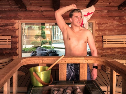 Wellnessurlaub - Klassifizierung: 4 Sterne - Bischofsmais - Blockbohlensauna (Event-Saunaaufgüsse) mit Panorama-Fenster  - Hotel Zum Kramerwirt