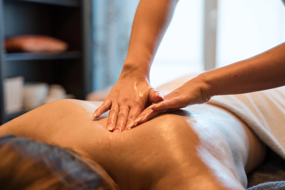 Wellnesshotel: Eine Frau genießt eine entspannende Rückenmassage im Wellnessbereich des Posthotels Rattenberg. - Posthotel Rattenberg - Sauna | Spa