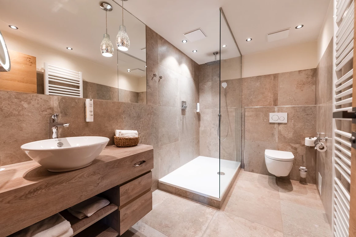 Wellnesshotel: Offenes Badezimmer in Beigetönen - Posthotel Rattenberg - Zimmer | Suiten