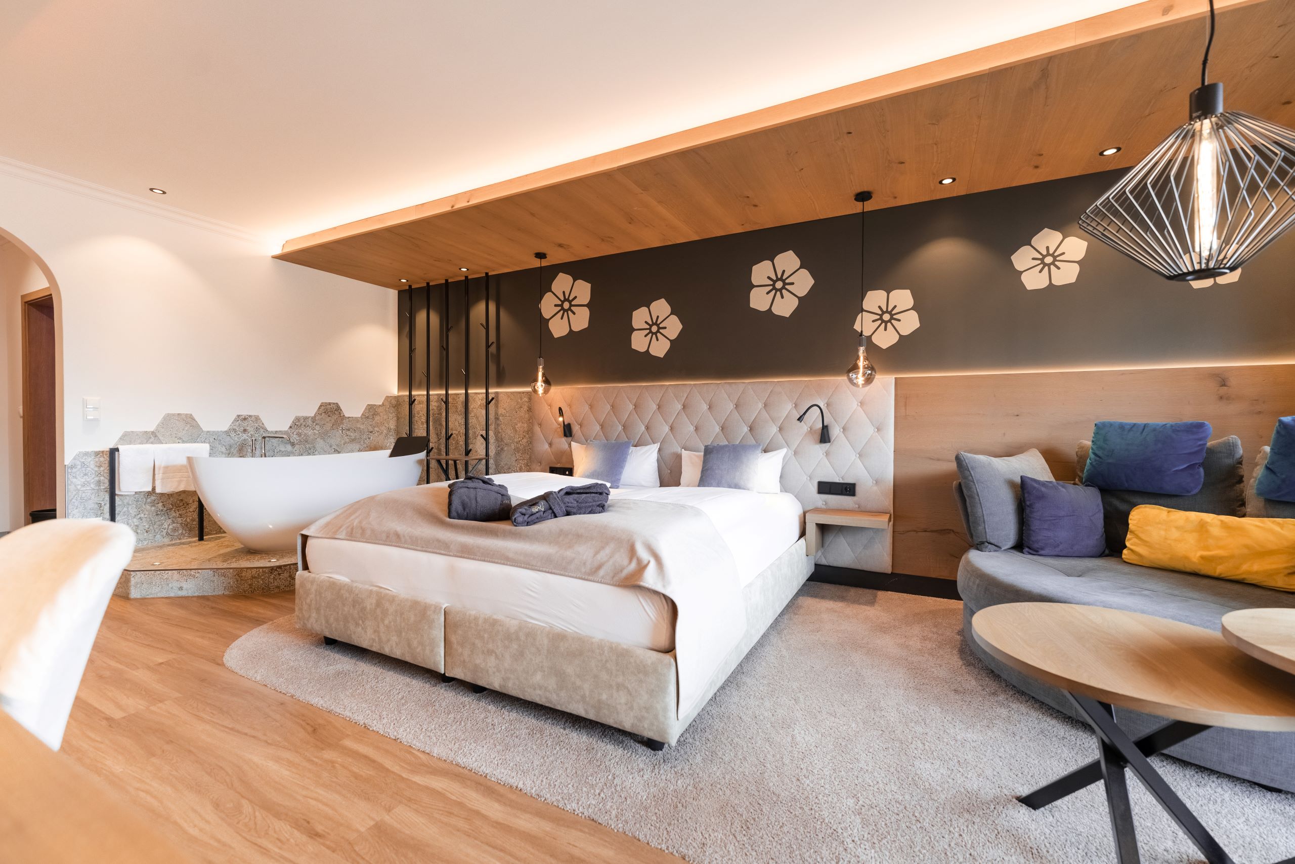 Wellnesshotel: Helles Schlafzimmer mit farblichen Pölstern im Hintergrund - Posthotel Rattenberg - Zimmer | Suiten