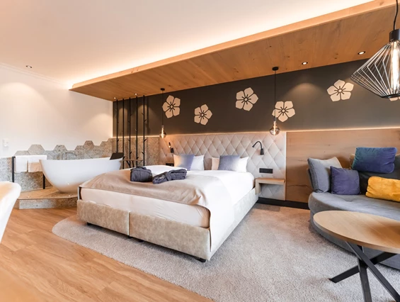 Wellnesshotel: Helles Schlafzimmer mit farblichen Pölstern im Hintergrund - Posthotel Rattenberg - Zimmer | Suiten