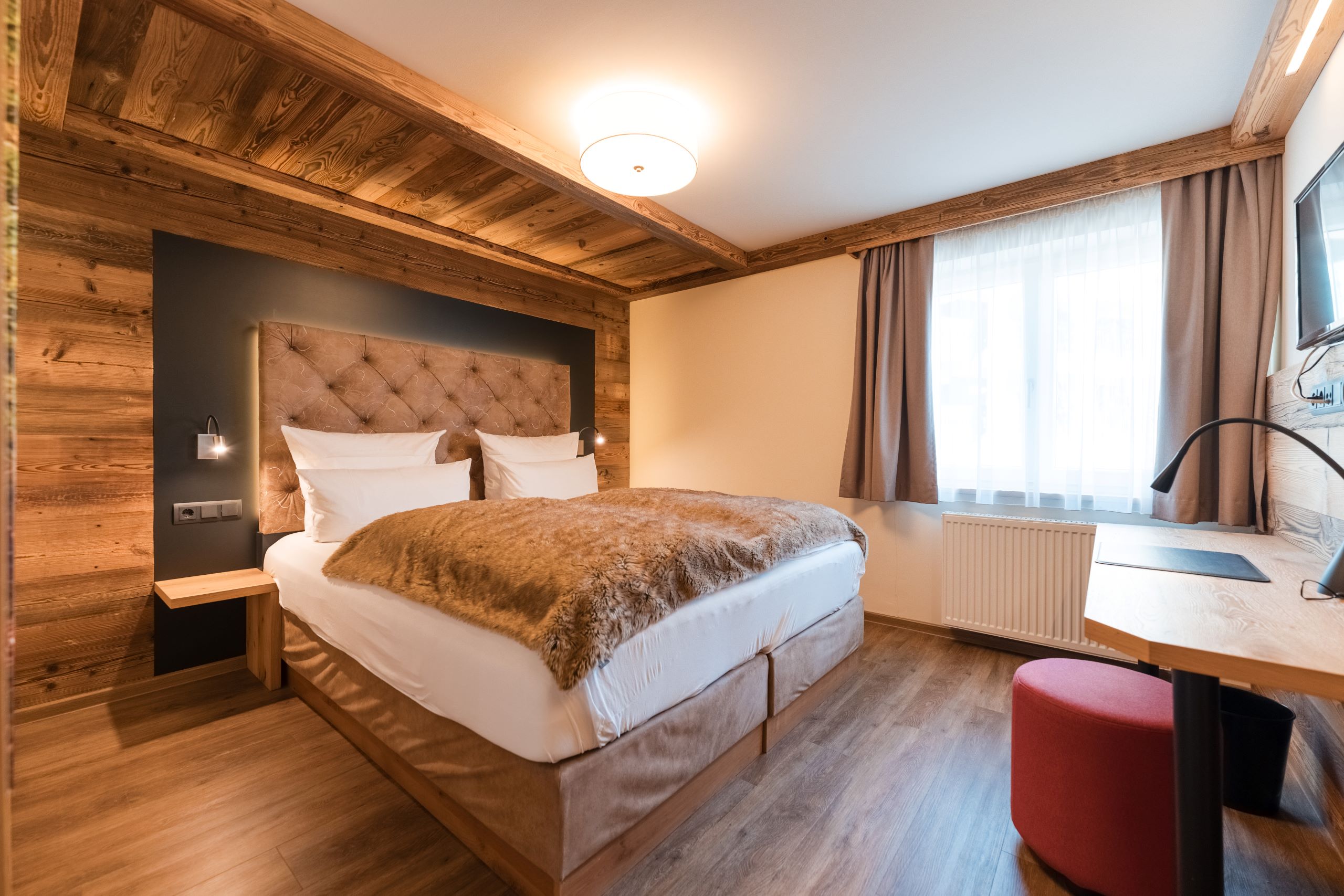 Wellnesshotel: Helle Hüttensuite mit brauner Decke auf dem bett und viel Holzelementen - Posthotel Rattenberg - Zimmer | Suiten