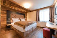 Wellnesshotel: Helle Hüttensuite mit brauner Decke auf dem bett und viel Holzelementen - Posthotel Rattenberg - Zimmer | Suiten