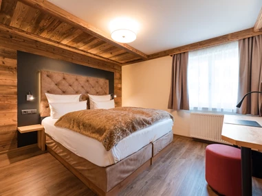 Wellnesshotel: Helle Hüttensuite mit brauner Decke auf dem bett und viel Holzelementen - Posthotel Rattenberg - Zimmer | Suiten