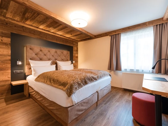 Wellnesshotel: Helle Hüttensuite mit brauner Decke auf dem bett und viel Holzelementen - Posthotel Rattenberg - Zimmer | Suiten