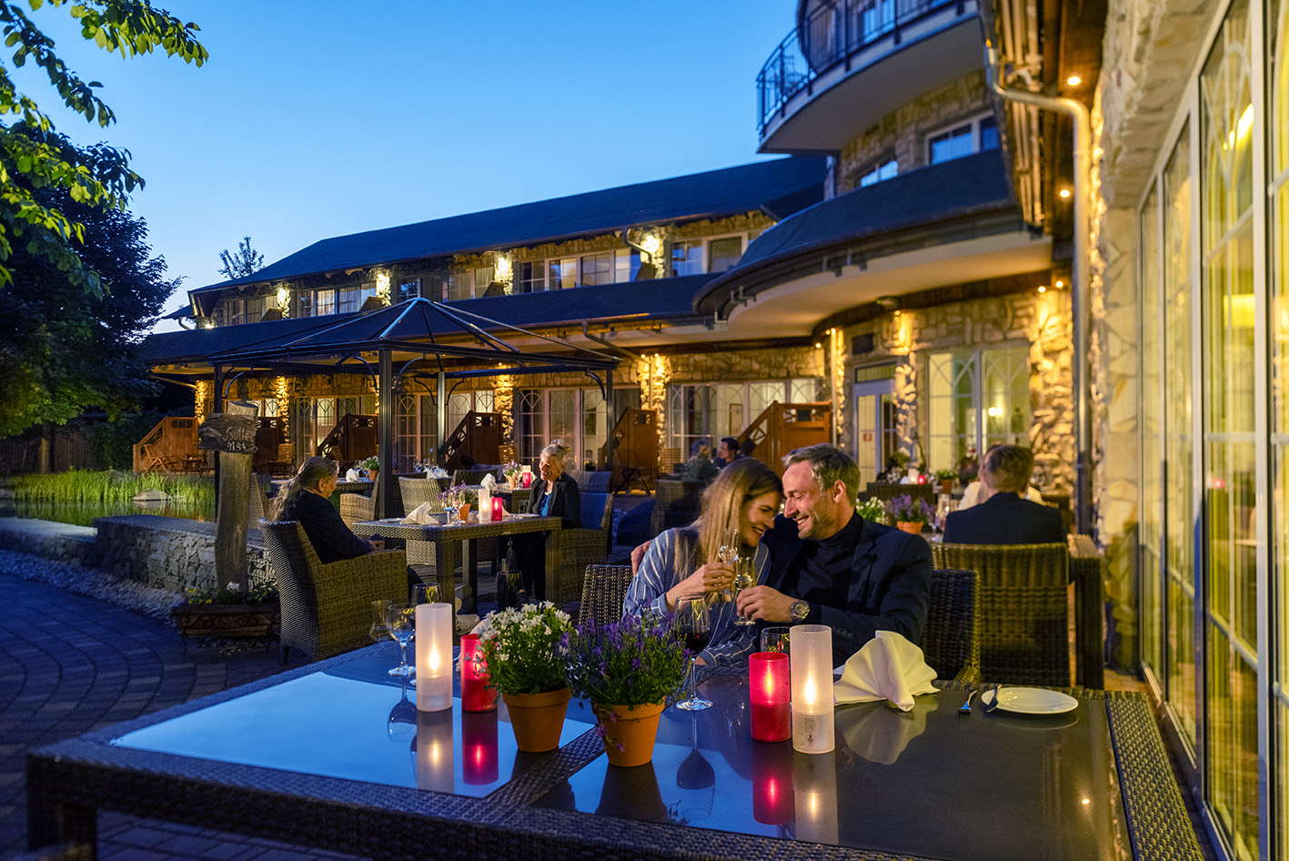 Wellnesshotel: Terrasse mit Paar in der Dämmerung - Wellnesshotel Seeschlösschen - Kulinarik | Restaurant