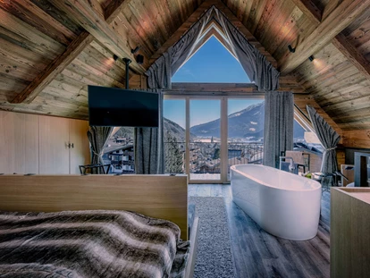 Wellnessurlaub - Maurach - Schlafzimmer mit freistehender Whirlwanne in der Gassner Baumhaus.Lodge - Hotel Gassner****Superior