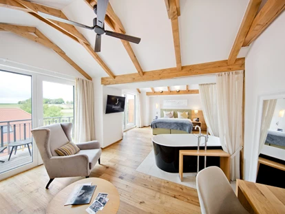 Wellnessurlaub - Maniküre/Pediküre - Flomborn - SPA Suite Wolke 7
Unsere Spa Suite „Wolke 7“ ist das Herzstück unserer Mühle No 7. Ländlicher Schick vereint sich zurückhaltend mit modernem Komfort. Die 40 m² Zimmerfläche inklusive eigenem Wohnbereich werden noch um einen Balkon erweitert, von dem Sie einen fantastischen Blick auf unseren Garten genießen. Die exklusive, freistehende Badewanne und der exquisite Weinkühlschrank machen Ihren genussvollen Aufenthalt in Jordan’s Untermühle zum unvergesslichen Erlebnis. In dem Boxspringbett träumen Sie bequem und ungestört von neuen Glücksmomenten. Zeit zum Entspannen in diesem warm und einladend gestalteten Ambiente mit hochwertigen Oberflächen und Materialien. - Hotel Jordan's Untermühle