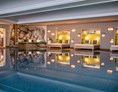 Wellnesshotel: Großes Schwimmbad mit gemütlichen Kuhfellbetten - Hotel Franks