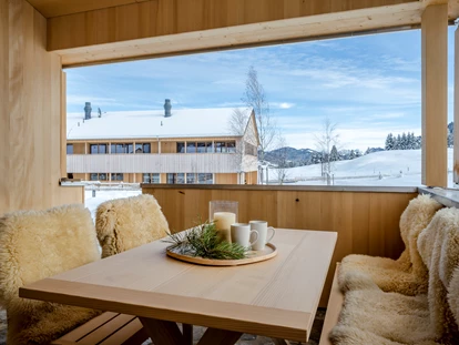 Wellnessurlaub - Fontanella - Inspiriert von der Vorsäß-Hütte ist das Flux Chalet mit dem Kamin ein kleines Stück heile Welt. Individueller Rückzugsort mit angenehm klarer Offenheit zur Natur. Der große, überdachte Schopf als Verandasitzplatz und der eigene Eingang sind privater Luxus, den man sich gerne gönnt. - Fuchsegg Eco Lodge