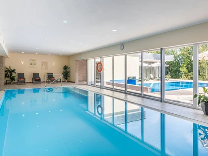 Wellnessurlaub - Finnische Sauna - Fladungen - Innenpool mit Blick zum Wald & Außenpool - AKZENT Aktiv & Vital Hotel Thüringen