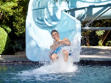 Feldhof DolceVita Resort Saunen und Bäder im Detail Kinderpool mit 35 Meter langer Wasserrutsche im Garten