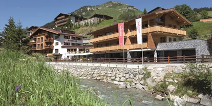 Wellnessurlaub - Babysitterservice - Aussenansicht Hotel Auenhof in Lech im Sommer - Hotel Auenhof