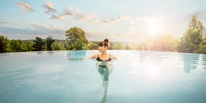 Wellnessurlaub - Restaurant - Stegersbach - Schweben im warmen Wasser und den Ausblick genießen – der Infinity Pool im AVITA Exklusiv ist Entspannung pur. - Avita Resort****Superior