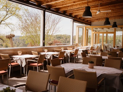 Wellnessurlaub - Restaurant - Stegersbach - Terrasse
Ein besonderer Höhepunkt ist unsere großzügige und überdachte Terrasse, die in den Sommermonaten geöffnet ist. Von hier aus eröffnet sich Ihnen ein einzigartiger Panoramablick über die sanften Hügel des Südburgenlandes, die sich in sattem Grün präsentieren. Genießen Sie an lauen Sommerabenden ein Abendessen bei Sonnenuntergang oder verweilen Sie bei einem erfrischenden Getränk und kleinen Köstlichkeiten zwischendurch. Die geschmackvolle Einrichtung der Terrasse sorgt dafür, dass Sie Ihren Besuch in vollen Zügen genießen können und jeden Aufenthalt als etwas Besonderes erleben - Das Eisenberg