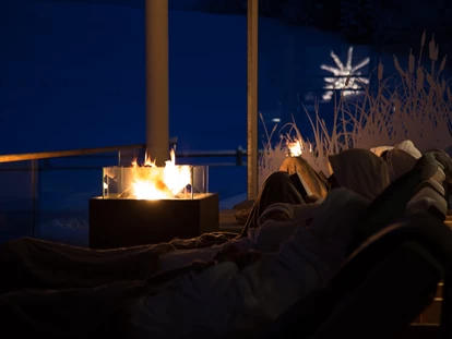 Wellnessurlaub - Fontanella - Das Feuer auf der Terrasse beim Haus am See sorgt für Wärme und Erholung. - Haubers Naturresort