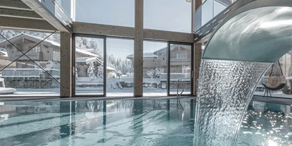 Wellnessurlaub - Private Spa - Otterbach (Sankt Florian am Inn) - INNs HOLZ Ausblick vom Indoorpool auf das Chaletdorf im Winter - INNs HOLZ Chaletdorf